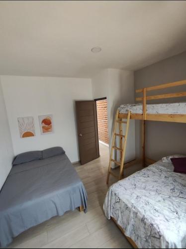 a bedroom with two bunk beds and a ladder at Casa Los Agaves in Zapotlanejo