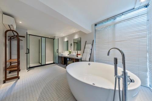 a large bathroom with a tub and a sink at 6號花園別墅酒店 Shenzhen No'6 Garden Villa --French Window with garden view,Close to Sea World &Shekou Ferry Port &K11 Ecoast &Subway Nearby ,Offer Western food and coffee &English speaking with tour services in Shenzhen