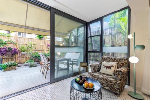 a living room with glass doors and a table at 6號花園別墅酒店 Shenzhen No'6 Garden Villa --French Window with garden view,Close to Sea World &Shekou Ferry Port &K11 Ecoast &Subway Nearby ,Offer Western food and coffee &English speaking with tour services in Shenzhen