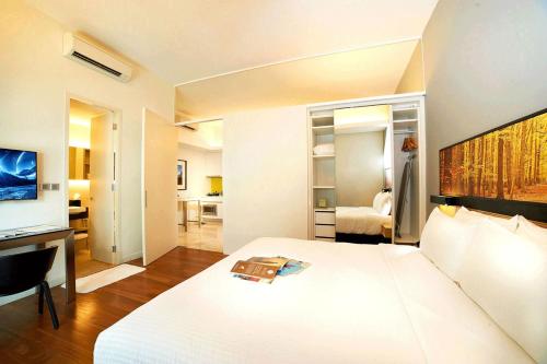 a hotel room with a white bed and a desk at The Signature Hotel & Serviced Suites Kuala Lumpur in Kuala Lumpur