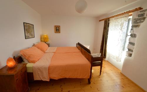 a bedroom with a bed with an orange bedspread and a window at Apartments Maja in Piran