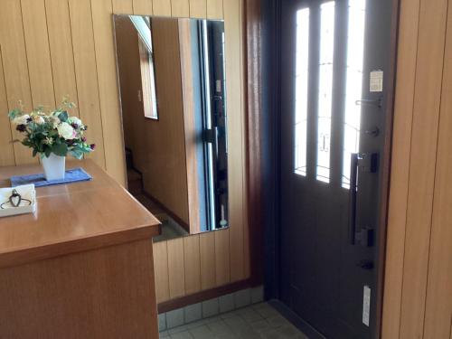 a bathroom with a door with a vase of flowers on a counter at Lemonso - Vacation STAY 19524 in Ichihara