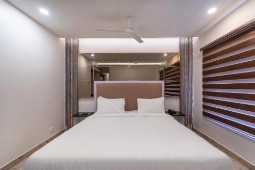 a bedroom with a large bed with white sheets at Palette - Coastal Grand Hotels & Resorts, OMR in Chennai