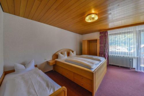 a bedroom with two beds and a large window at Hotel Gasthof Heckl in Kinding