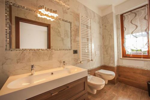 La salle de bains est pourvue d'un lavabo, de toilettes et d'un miroir. dans l'établissement B&B Holidays Artisti, à Peschiera del Garda