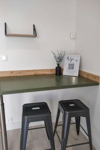 a green desk with two stools in front of it at Family Villa Overlooking Lake Serre-Ponçon in Savines