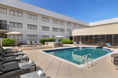 an image of a hotel pool with chairs and tables at Homewood Suites by Hilton Indianapolis Carmel in Carmel