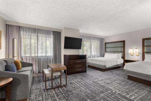 a hotel room with two beds and a television at Homewood Suites by Hilton Indianapolis Carmel in Carmel