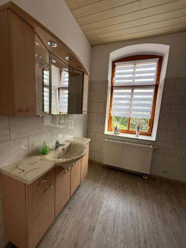 a bathroom with a sink and a mirror and a window at Fewo zum Klosterhof OG 2 in Nienhagen