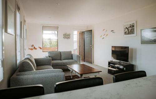 a living room with two couches and a tv at Kooringal - Your Home by the Ocean in Bicheno in Bicheno