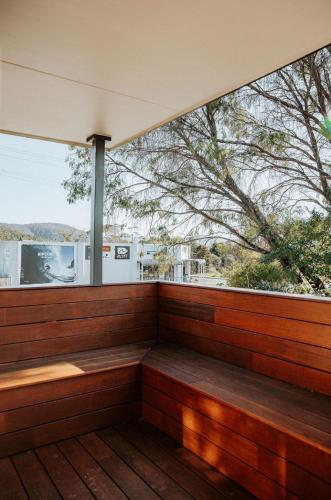 a wooden balcony with a large window in a house at Kooringal - Your Home by the Ocean in Bicheno in Bicheno
