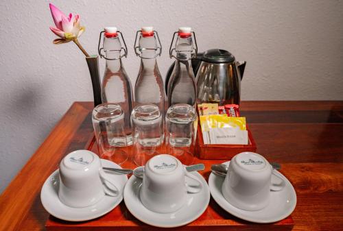 a wooden table with tea sets and wine bottles at Hotel Somadevi Angkor Resort & Spa in Siem Reap