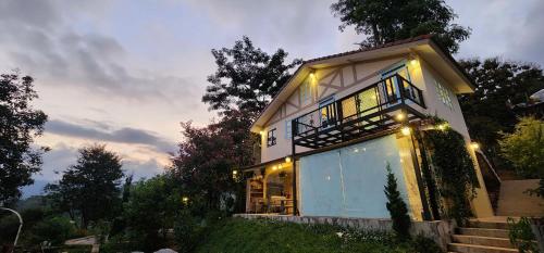 a house with lights on the side of it at Flora Prairie at Mae Rim, Chiang Mai in Ban Tai