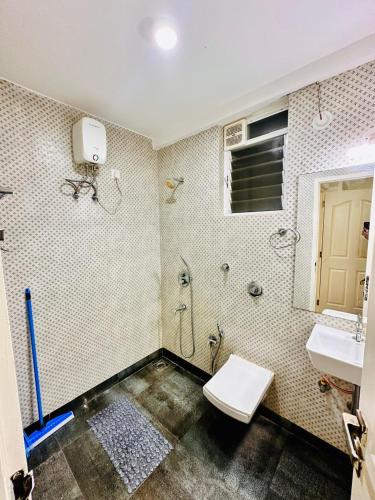 a bathroom with a toilet and a sink at Palm View 1BHK with Pool & Café - Sazo Stays in Goa