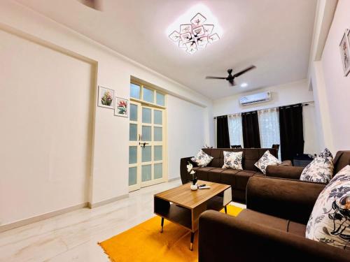 a living room with a couch and a table at Palm View 1BHK with Pool & Café - Sazo Stays in Goa
