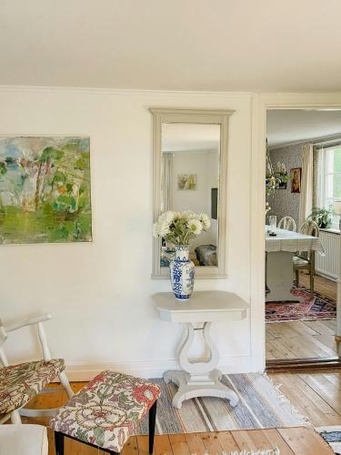 a room with a table with a vase of flowers on it at Country Villa From 1929 Near Öland Bridge in Färjestaden