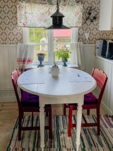 a white dining room table with two chairs and a window at Country Villa From 1929 Near Öland Bridge in Färjestaden