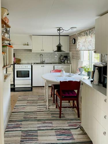 a white kitchen with a table and chairs in it at Country Villa From 1929 Near Öland Bridge in Färjestaden