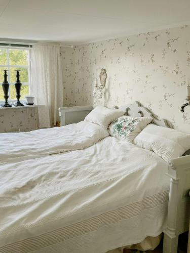 a large white bed in a bedroom with a window at Country Villa From 1929 Near Öland Bridge in Färjestaden