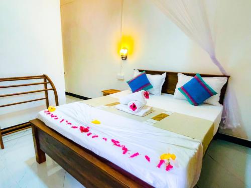 a bedroom with a bed with flowers on it at Sigiri Rew Haven in Sigiriya