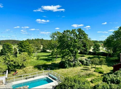 une vue aérienne d'une piscine dans un champ avec des arbres dans l'établissement Historic Cottages At The 18Th Century Vicarage, à Varmlands Nysater