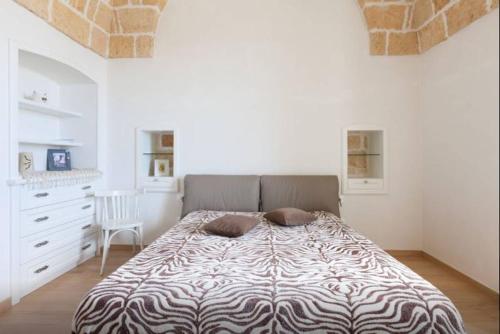 a bedroom with a large bed in a white room at Casa Vittorio Veneto in Carovigno