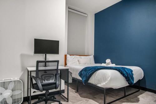 una camera da letto con un letto, una scrivania e una sedia di CozySuites Stunning 1BR in Downtown Pitts 39 a Pittsburgh