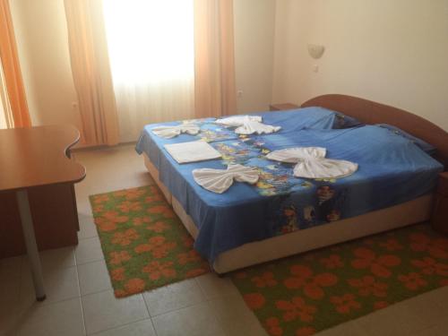 a bedroom with a blue bed with clothes on it at Apartments in Villa Rouge in Sozopol