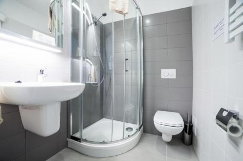 a bathroom with a shower and a toilet and a sink at Apple Inn in Warsaw