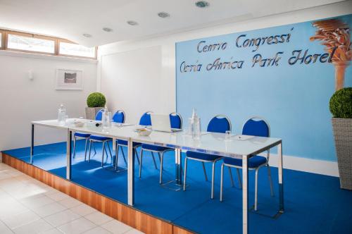 a conference room with a long table and blue chairs at Ostia Antica Park Hotel & Spa in Ostia Antica