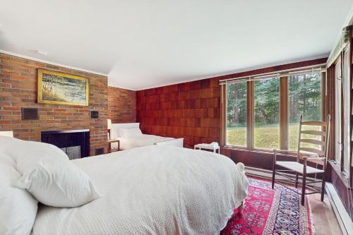 a bedroom with a white bed and a brick wall at Lincoln Gap Retreat in Warren