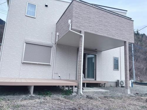 a house with a bench in front of it at にじいろ邸1階 in Fujiyoshida