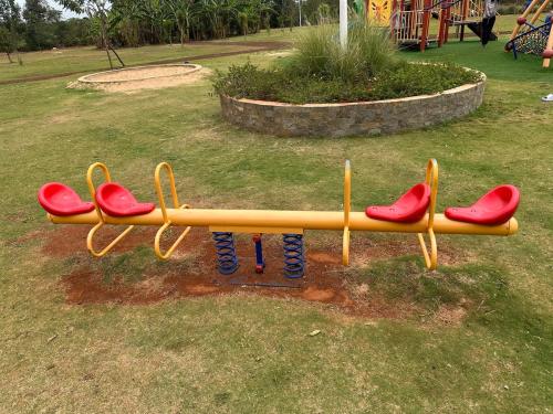 ナイロビにあるRestful Escape- 2br with Pool TatuCityの遊び場にある赤い座席の黄色いベンチ