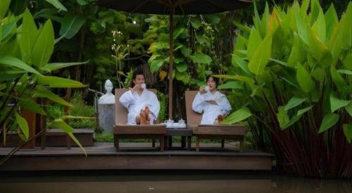 two men in bath suits sitting in a bath tub at My BanLao Hotel in Luang Prabang