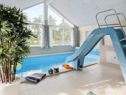 a indoor swimming pool with a slide in a house at Luxury Pool Villa in Marielyst - By Traum Ferienwohnungen in Marielyst
