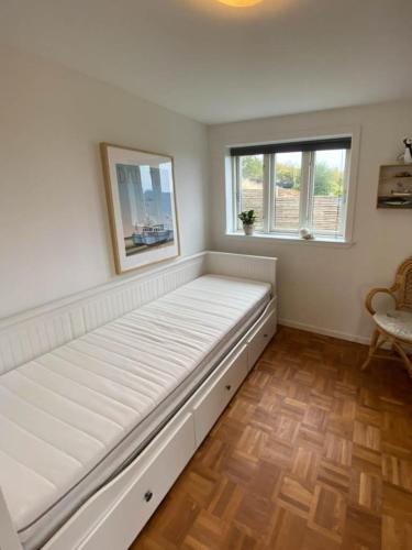 a large white bed in a room with two windows at Holiday Home With Panoramic Views Of Kolding Fjord in Kolding