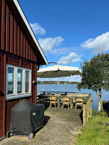 a patio with an umbrella and tables and chairs at Holiday Home With Panoramic Views Of Kolding Fjord in Kolding