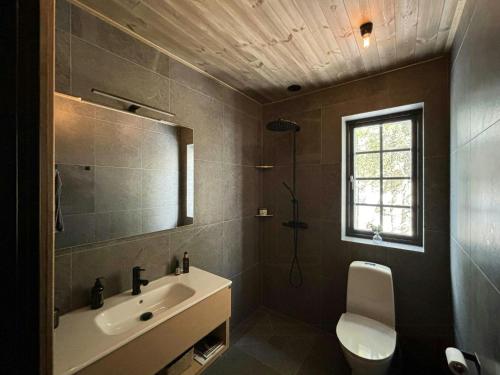 a bathroom with a sink and a toilet and a window at Mountain Cabin With Views Over Jämtland's Expanse in Storhågna