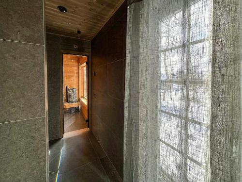 a bathroom with a shower curtain and a window at Mountain Cabin With Views Over Jämtland's Expanse in Storhågna