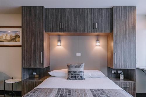 a bedroom with a large bed with wooden cabinets at 429 Apartments & Suites in Hobart