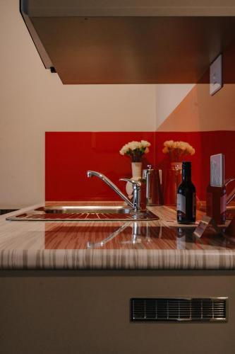 a kitchen with a sink and a red wall at 429 Apartments & Suites in Hobart