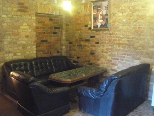 a living room with a leather couch and a table at Centro bustas in Kėdainiai
