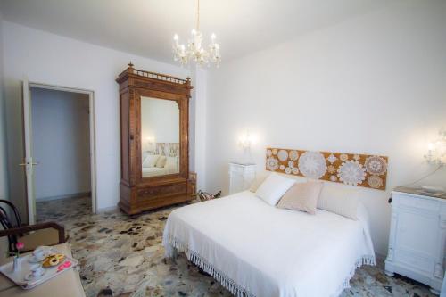 a bedroom with a white bed and a mirror at Bari Grand Central Apartment in Bari