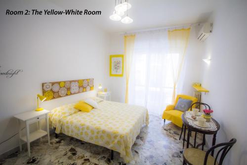 um quarto com uma cama e um quarto branco amarelo em Bari Grand Central Apartment em Bari