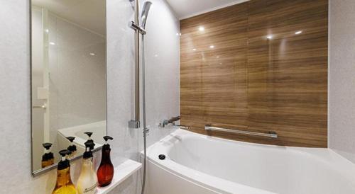 a bathroom with a bath tub with bottles on the counter at Hotel Dream Gate Maihama in Chiba