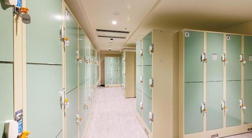 a locker room with green lockers and a hallway at Hotel Dream Gate Maihama in Chiba