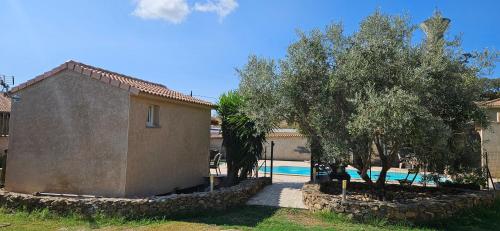 un bâtiment avec des arbres à côté d'une piscine dans l'établissement Bed and kitchen with pool, à Aléria