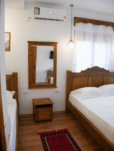 a bedroom with a bed and a mirror at Villa Marie 23 in Gjirokastër