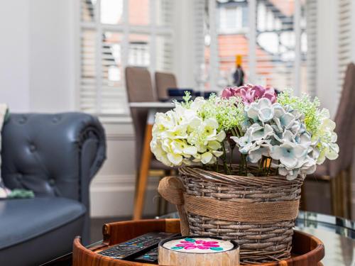 a basket of flowers sitting on a table at Sea Shore Flat in Llandudno