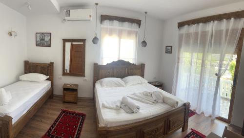 a bedroom with two beds and a window at Villa Marie 23 in Gjirokastër